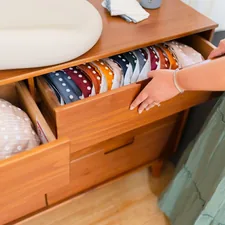 a woman is holding a drawer full of clothes related to Secondhand Style: Where Vintage Meets Versatility