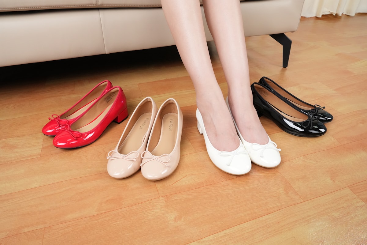 A woman sitting on a couch next to three pairs of shoes related to Affordable Elegance: The Ultimate Guide to Cheap Platform Bed Frames