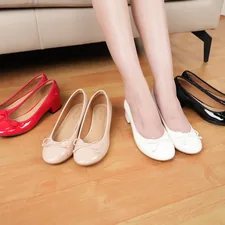A woman sitting on a couch next to three pairs of shoes related to Affordable Elegance: The Ultimate Guide to Cheap Platform Bed Frames