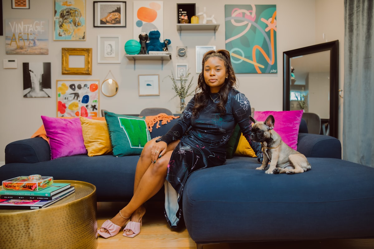 a woman sitting on a couch with a dog related to Styling Your Home with a Pop of Color: The Red Scarf Valance