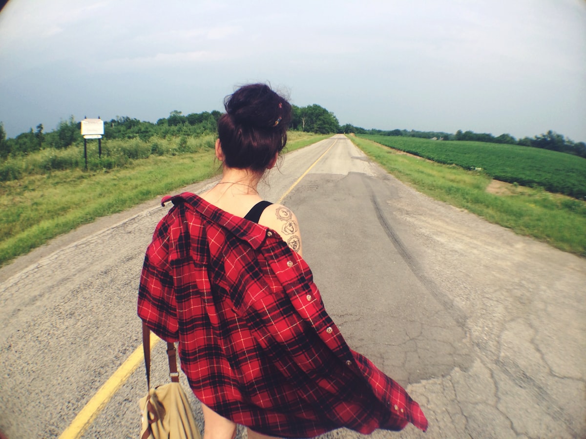 a woman walking down a road with a handbag related to Red Plaid Valance
