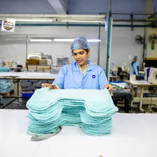 A woman works in a factory related to The Ultimate Guide to Disposable Bed Pads: Comfort and Convenience