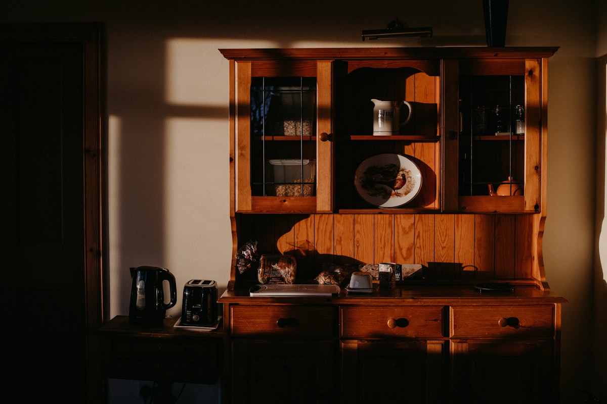 A wooden cabinet in the morning light, waiting for me to put on the kettle and fill up a cup of coffee. related to Mastering the Art of Sideboards and Hutch Storage Solutions
