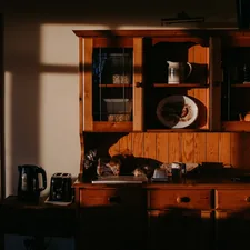 A wooden cabinet in the morning light, waiting for me to put on the kettle and fill up a cup of coffee. related to Mastering the Art of Sideboards and Hutch Storage Solutions