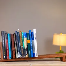 a wooden shelf with a lamp and books on it related to Maximizing Space: The Ultimate Guide to Over Bed Shelves