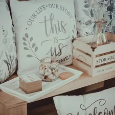 A wooden table topped with lots of pillows related to Elevate Your Home Decor: A Guide to Kmart Curtains and Valances