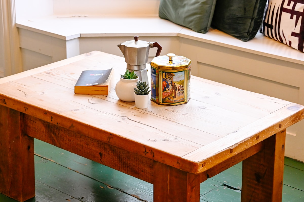 A wooden table with a book and a vase on it related to Crafting the Perfect Entryway Bench: A Comprehensive Guide to Woodworking Plans