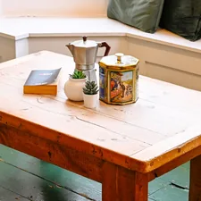 A wooden table with a book and a vase on it related to Crafting the Perfect Entryway Bench: A Comprehensive Guide to Woodworking Plans