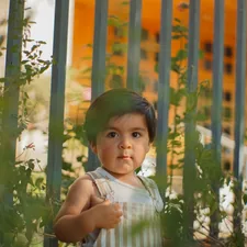 a young child standing in front of a fence related to Essential Guide to Choosing the Best Rail for Toddler Bed