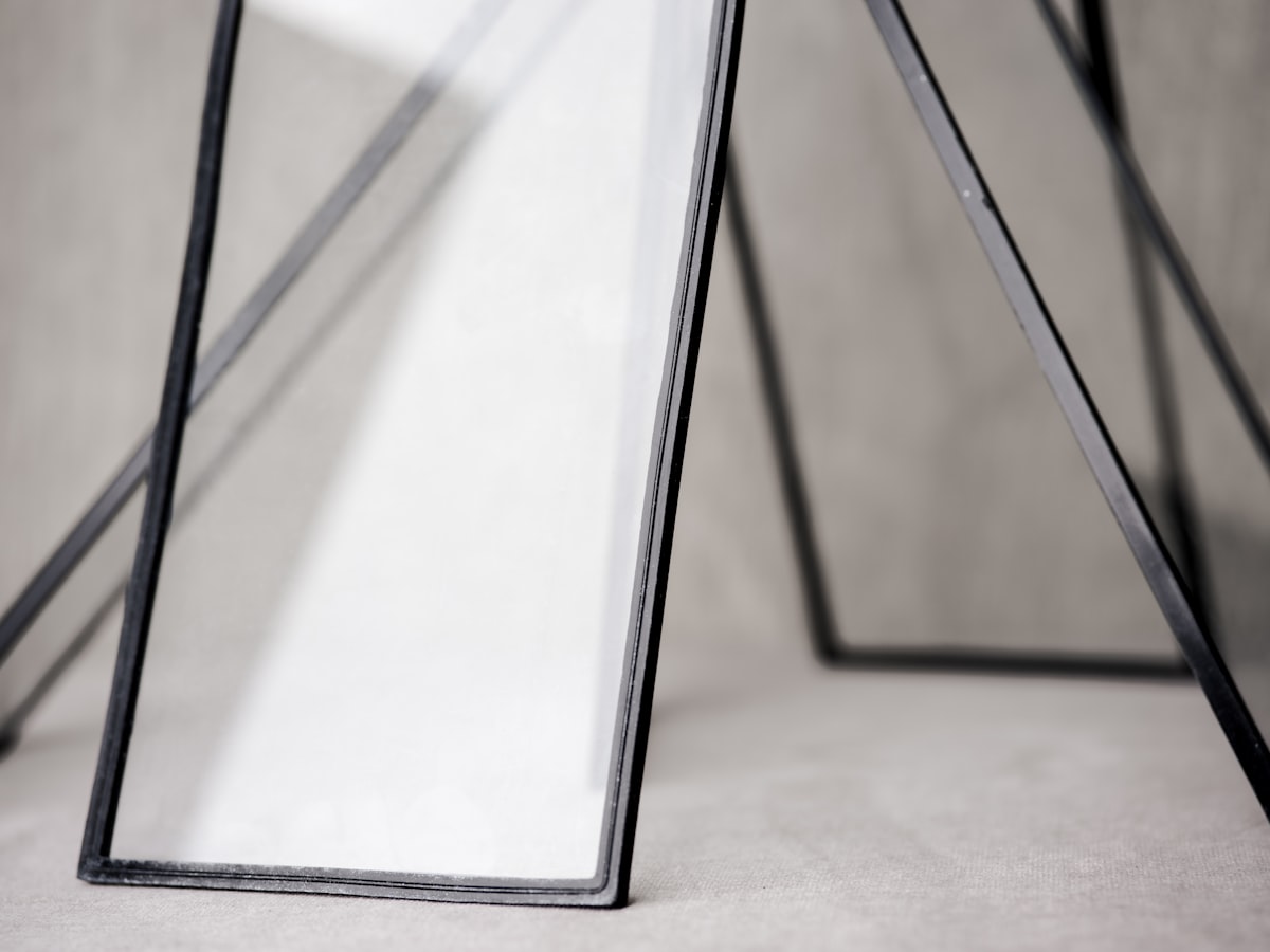 Abstract glass frames leaning against a backdrop. related to Elegance in Dark: The Allure of Black Glass Sideboards