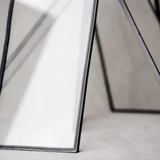 Abstract glass frames leaning against a backdrop. related to Elegance in Dark: The Allure of Black Glass Sideboards