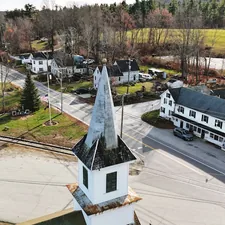 Aerial view of a small town with a church steeple. related to Discover the Charm of Bed and Breakfasts in New Hampshire