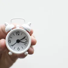 Alarm clock friends situation with hand related to The Sweet Spot: What Time Do I Need to Go to Bed?