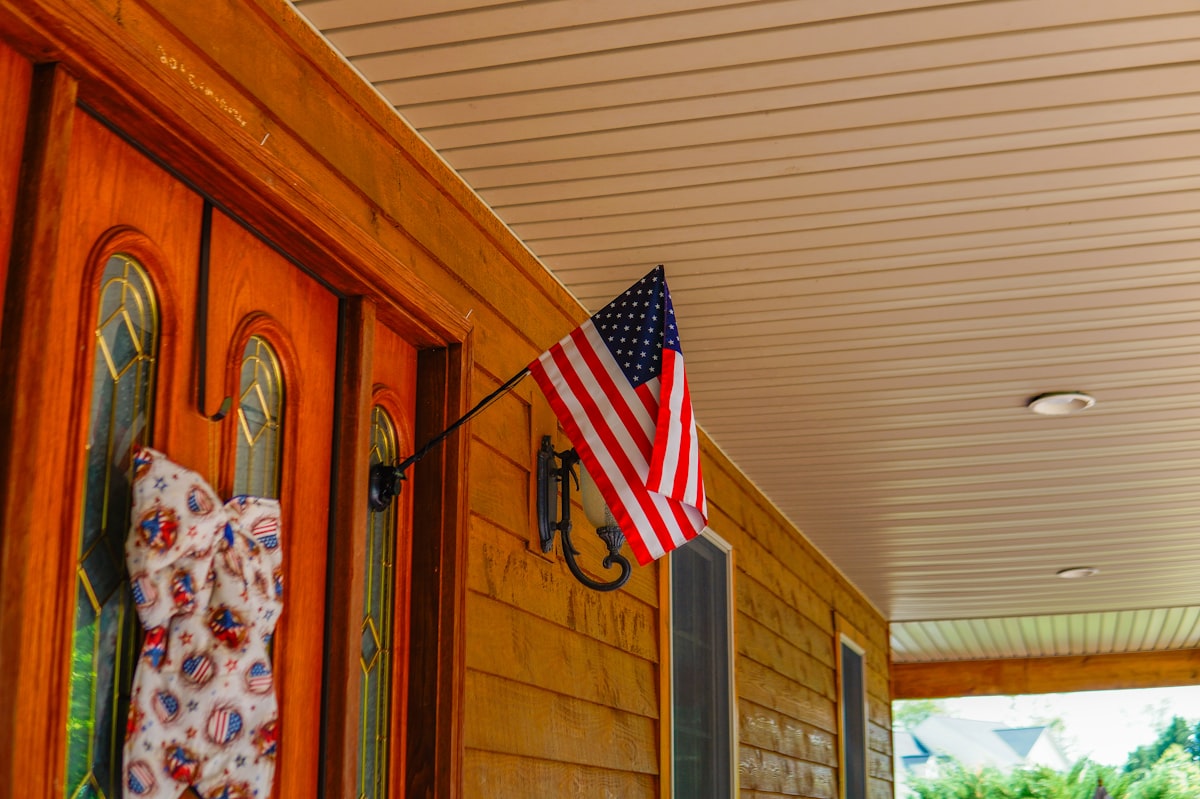 American flag at front door of wooden hous related to Spruce Up Your Home's First Impression: Outside Entryway Decor Ideas
