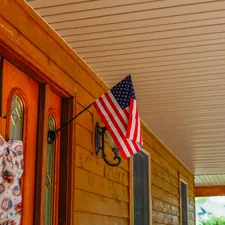 American flag at front door of wooden hous related to Spruce Up Your Home's First Impression: Outside Entryway Decor Ideas