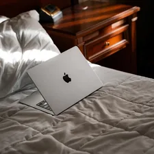 An apple laptop sitting on top of a bed related to Luxurious Satin Coverlets Bedspreads for a Stylish Bedroom