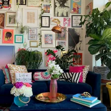 An eclectic gallery wall in a colorful maximalist apartment home in Denver, Colorado  related to Styling Your Home with a Pop of Color: The Red Scarf Valance