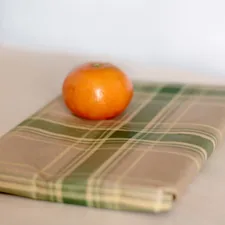 an orange sitting on top of a napkin on a table related to Full Size Coverlet