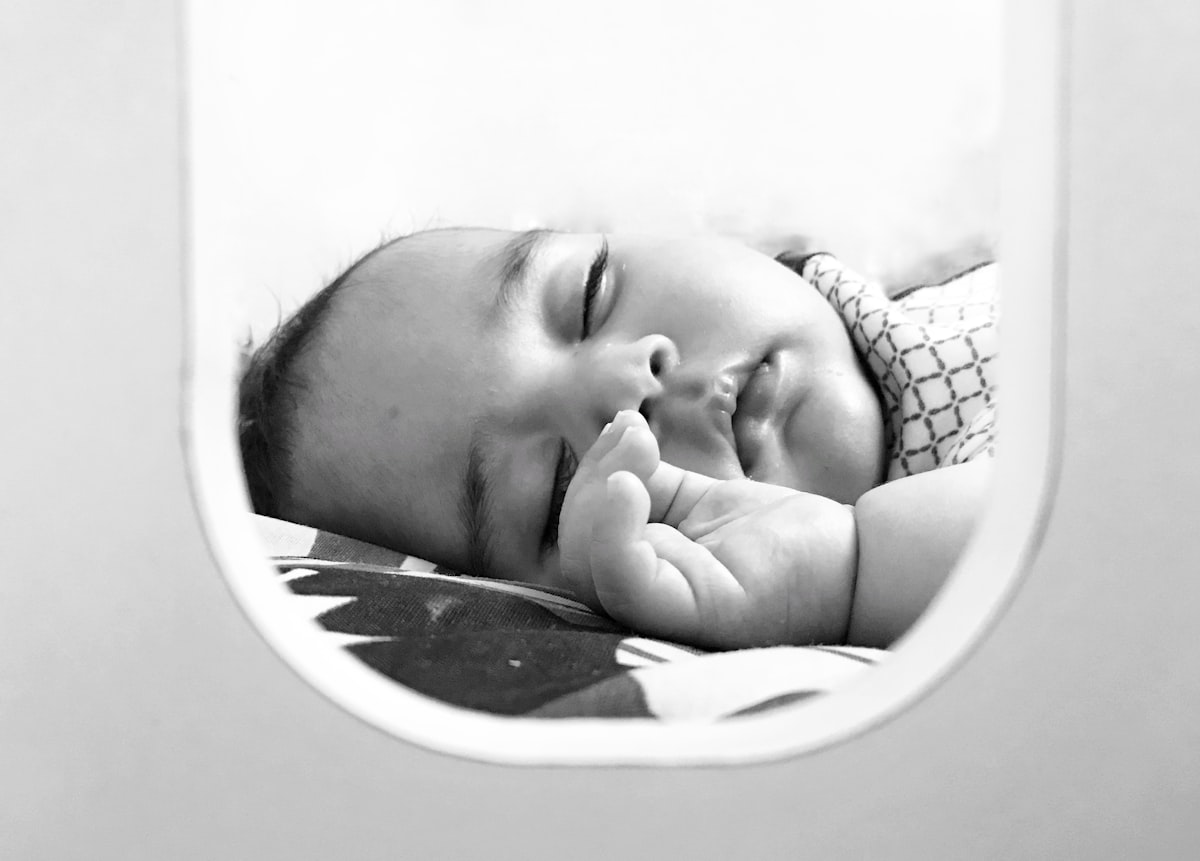 Asleep baby in bed like airplane , cute baby sleeping baby hand up white baby black and white baby photo related to Trunkful of Dreams: Unique Baby Elephant Crib Bedding