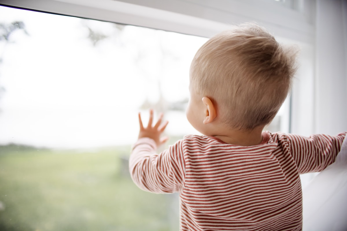 Baby Boy looking out the window related to Top Tips for Choosing the Perfect Kids Window Valance