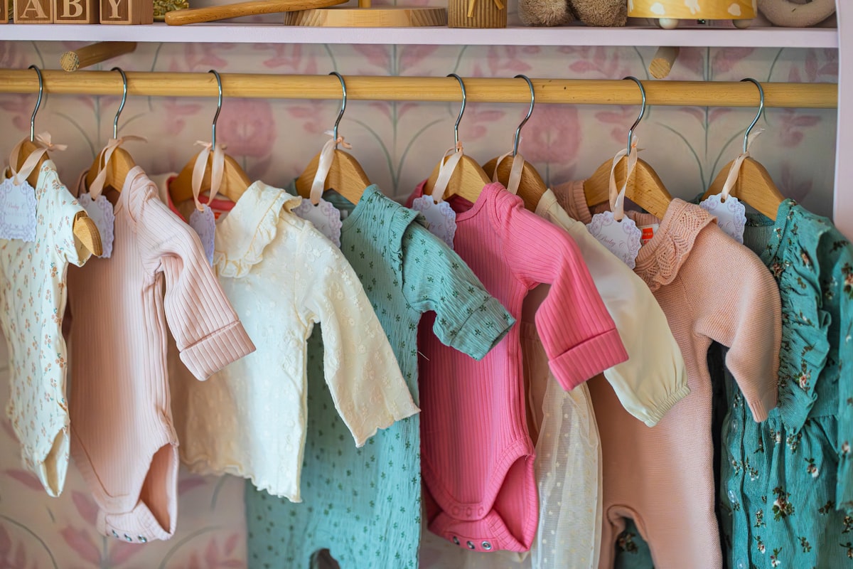 Baby clothes hanging on a rack related to Valances for Nursery