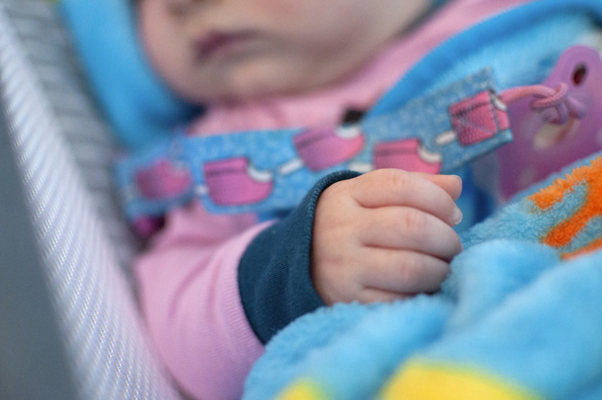 baby in blue and pink shirt related to A Perfect Match: Pink and Turquoise Crib Bedding