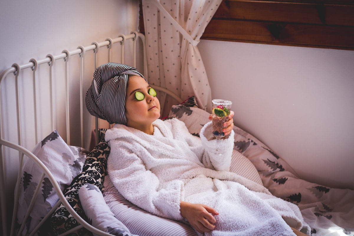 baby in white sweater and yellow goggles lying on bed related to The Benefits of Using a Bed Bath and Beyond Steamer