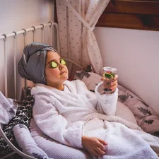 baby in white sweater and yellow goggles lying on bed related to The Benefits of Using a Bed Bath and Beyond Steamer