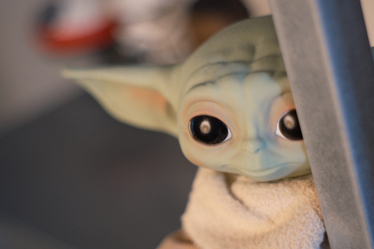 Baby yoda toy peeking curiously. related to A Galaxy Far, Far Away: Star Wars Crib Bedding for Little Jedi