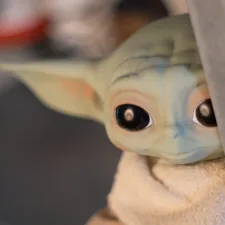 Baby yoda toy peeking curiously. related to A Galaxy Far, Far Away: Star Wars Crib Bedding for Little Jedi
