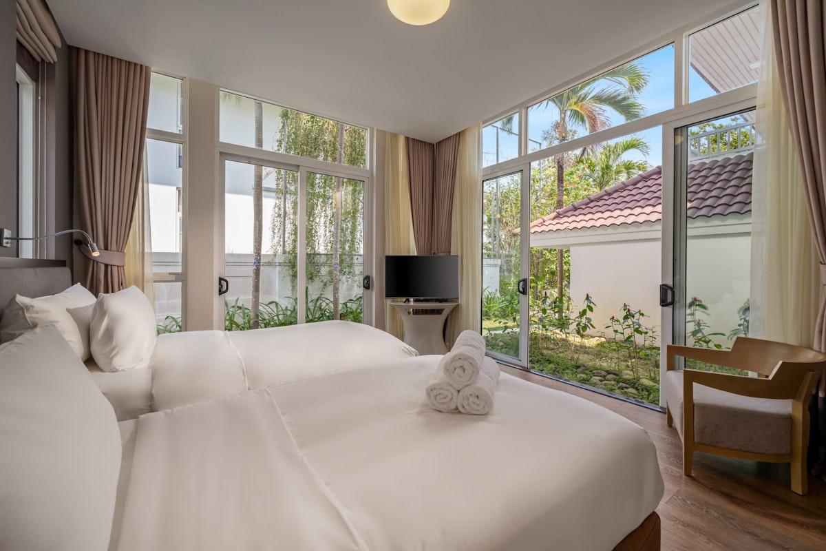 Bedroom with two beds and large windows overlooking garden related to Contemporary Luxury Bedding