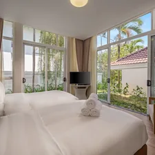 Bedroom with two beds and large windows overlooking garden related to Contemporary Luxury Bedding
