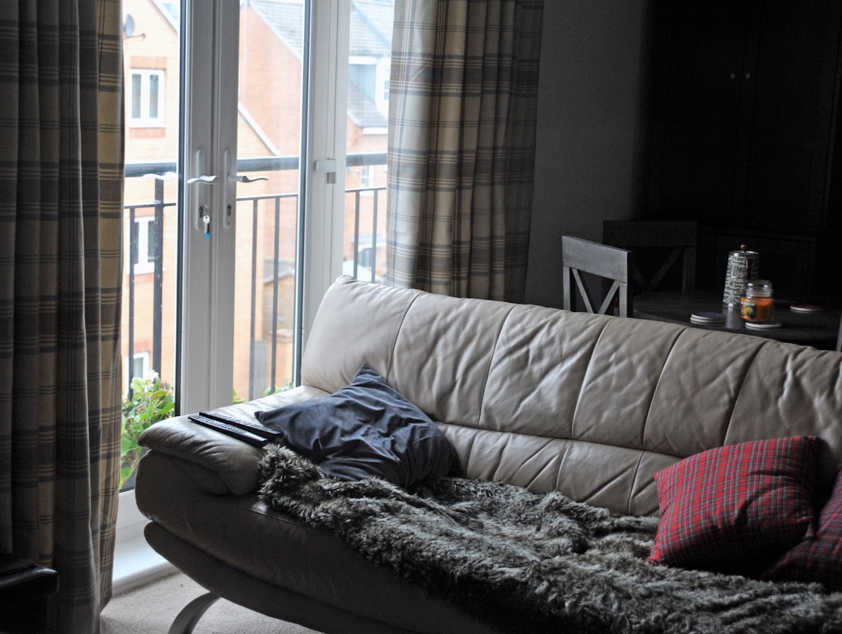 black and gray blanket on gray couch related to Plaid Curtain Valances: Adding a Touch of Rustic Charm to Your Home