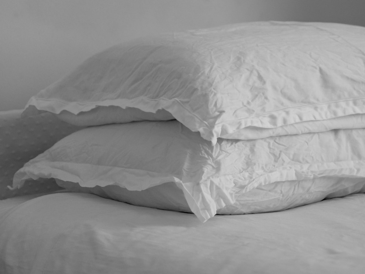 Black and white image of wrinkled linen pillow on a bed.  related to Exploring the World of King Size Coverlets