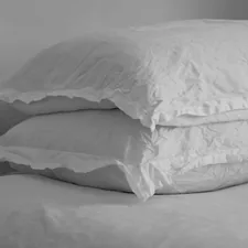 Black and white image of wrinkled linen pillow on a bed.  related to Exploring the World of King Size Coverlets