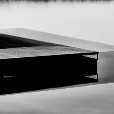 black and white wooden dock on calm water related to Floating Above Reality: Exploring Magnetic Floating Beds