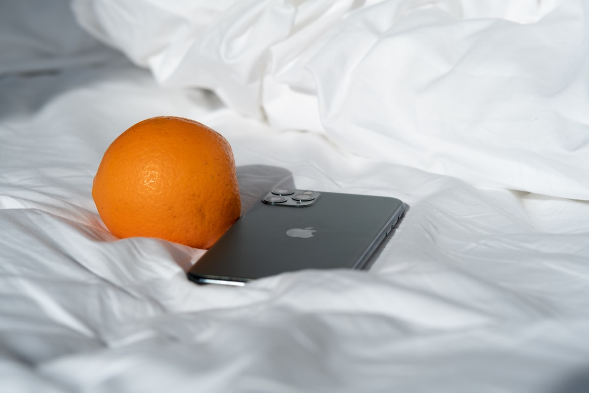 black asus laptop beside orange fruit related to Transform Your Bedroom with Vibrant Orange Bedding Sets