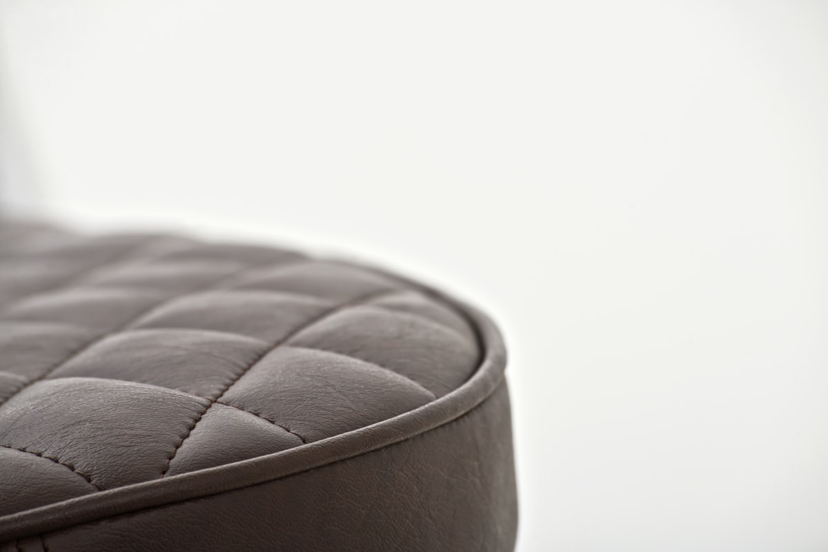 black leather round ottoman on white background related to Luxurious Comfort and Style with Upholstered Beds