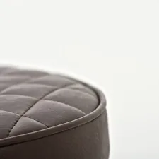 black leather round ottoman on white background related to Luxurious Comfort and Style with Upholstered Beds