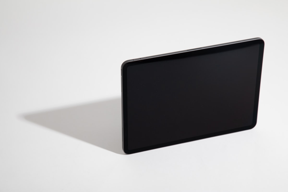 black tablet computer on white table related to Elegance in Dark: The Allure of Black Glass Sideboards