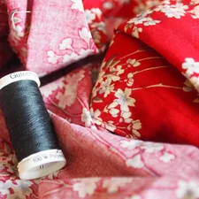 black thread on red and white floral textile related to Sew a Beautiful Valance: A Step-by-Step Guide