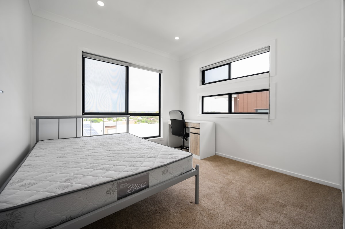 black wooden bed frame with white bed linen related to Exploring the Charm of 2 Bed Apartments: Your Perfect Urban Sanctuary