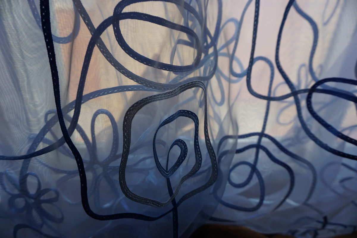 Blue sheer curtain with abstract dark blue floral pattern related to The Ultimate Guide to Curtain Scarf Valances: Transforming Your Windows with Style