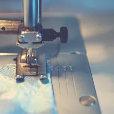 blue textile under a sewing machine needle related to Sew a Beautiful Valance: A Step-by-Step Guide