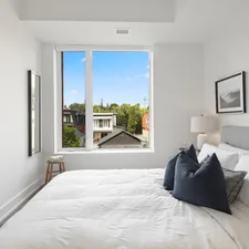 blue throw pillow on white bed related to Exploring Bed-Stuy Real Estate: The New Hotspot for Investors and Homebuyers