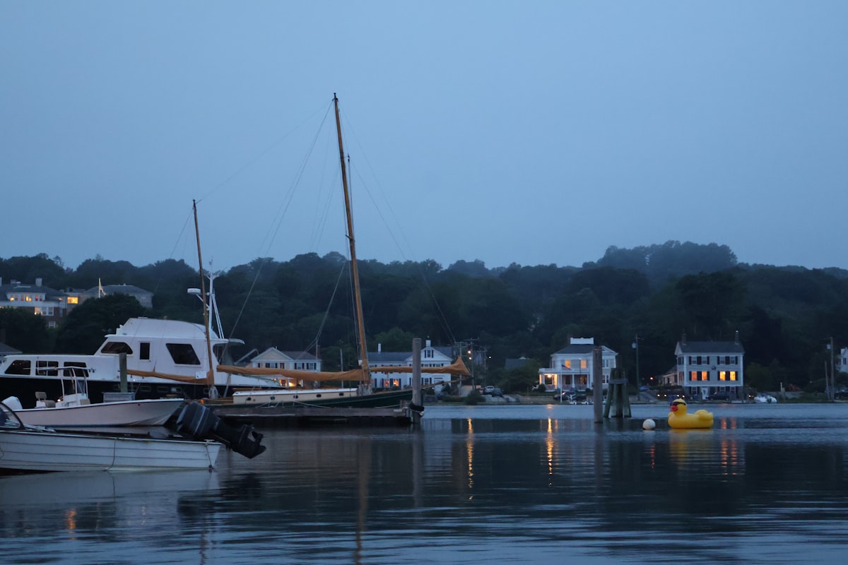 Boats in the harbor at dusk, by the shore. related to Discovering the Charm of Bed and Breakfasts in Mystic, CT