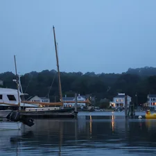 Boats in the harbor at dusk, by the shore. related to Discovering the Charm of Bed and Breakfasts in Mystic, CT