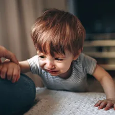 boy in gray and white striped shirt sitting on floor related to Clever Options: Crib Alternatives for Tiny Tot's Transition