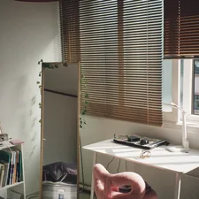 Bright room with a desk, pink chair, and window blinds related to Transform Your Dorm Room with Cynthia Rowley Bedding Twin XL