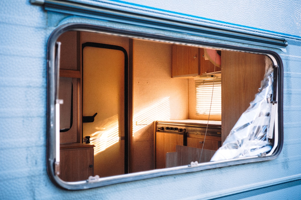 Broken window on a light blue caravan interior related to Choosing the Best Ladder for Your RV Bunk Bed